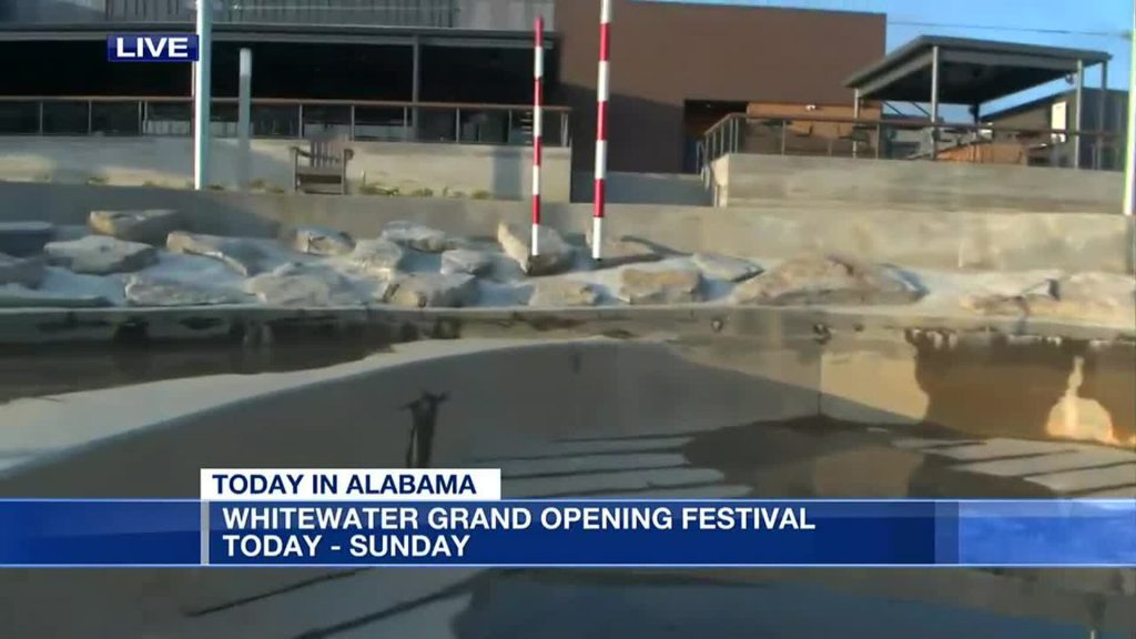 A news broadcast screen shows a modern water park, showcasing impressive civil engineering with rocks and a calm water area. Text on the screen reads: Today in Alabama. Whitewater Grand Opening Festival. Today - Sunday.