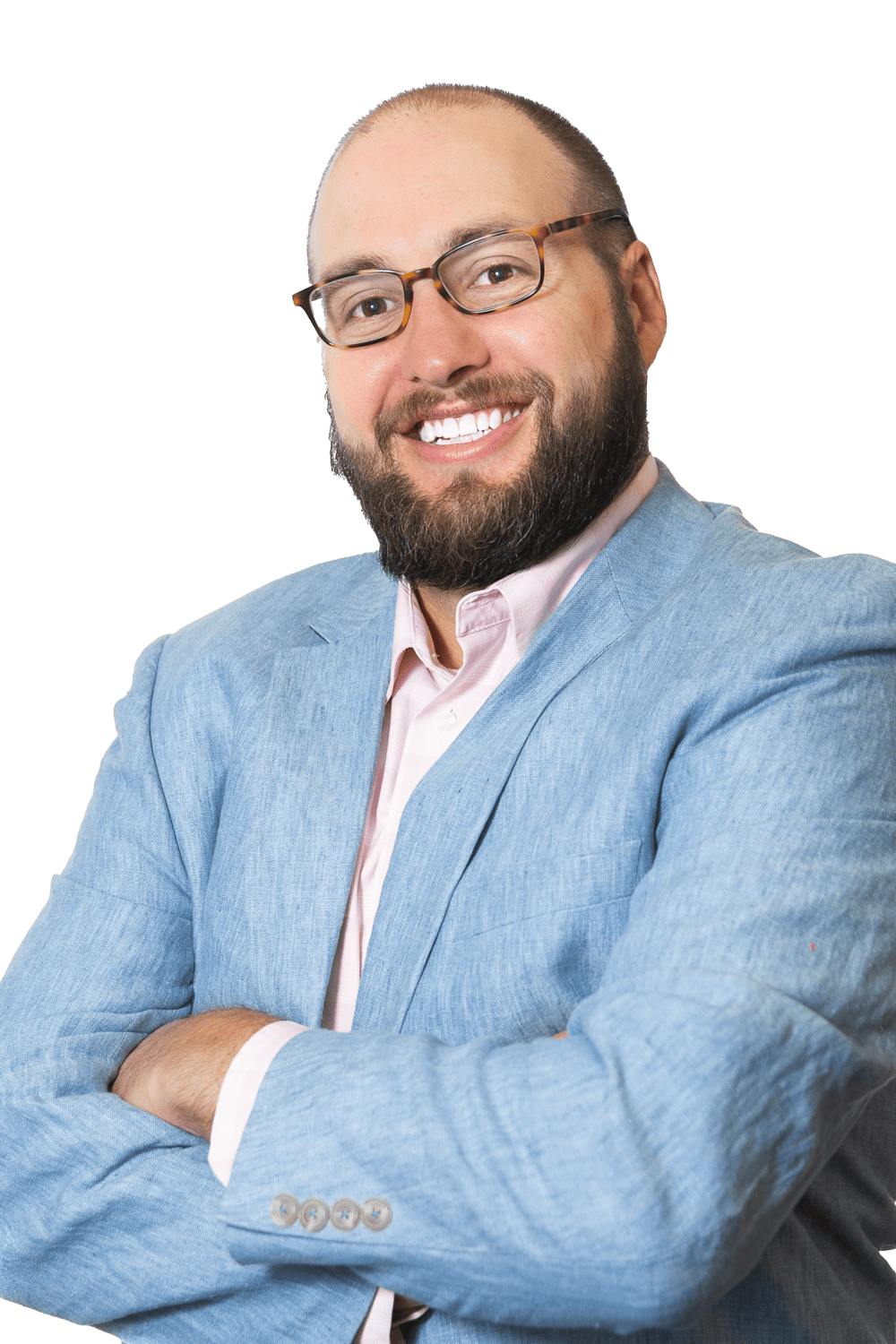 A smiling man with glasses and a beard, dressed in a light blue blazer over a pink shirt, stands with arms crossed—embodying the confidence of a Colorado engineering professional or civil engineering expert against a transparent background.