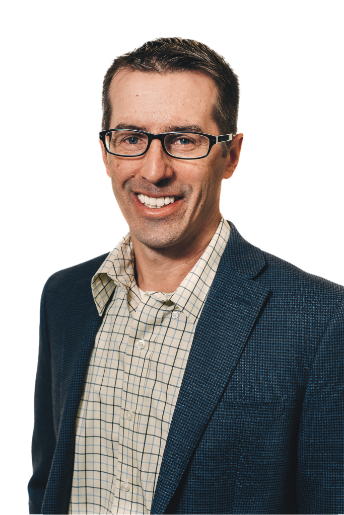 A man wearing glasses, a blue textured blazer, and a light plaid shirt smiles at the camera against a plain background, capturing the approachable style of a Denver engineer.